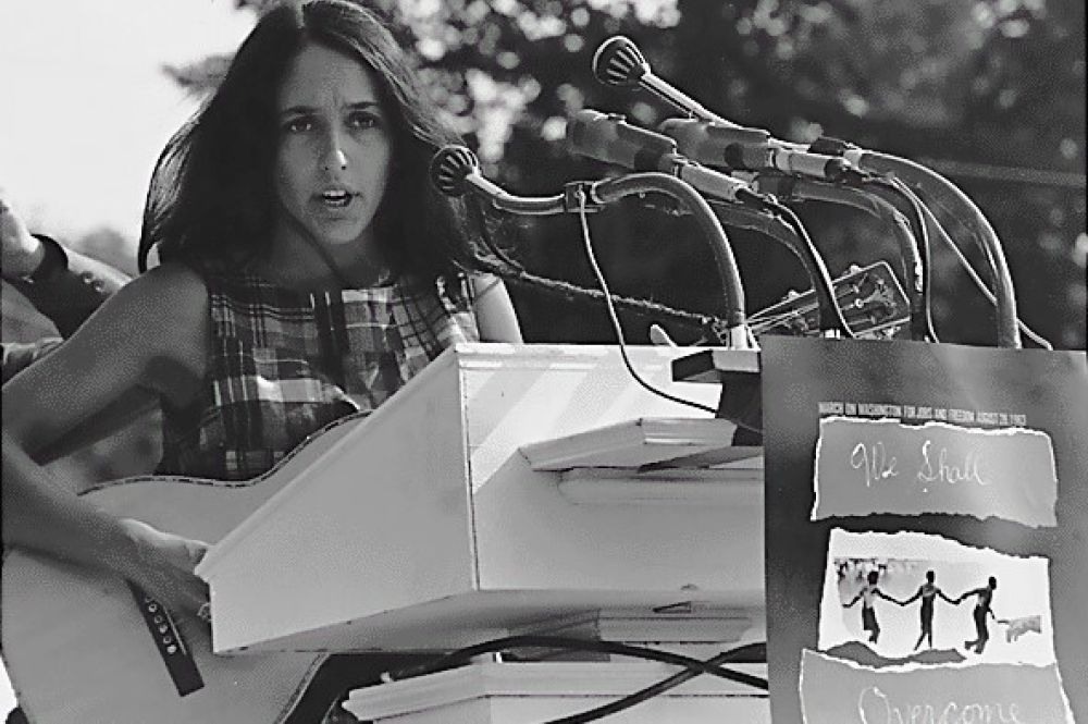 Civil Rights March on Washington, D.C. Joan Baez. vor einem Schild vor dem Mikrophon mit dem Slogan "We Shall Overcome" 1963.